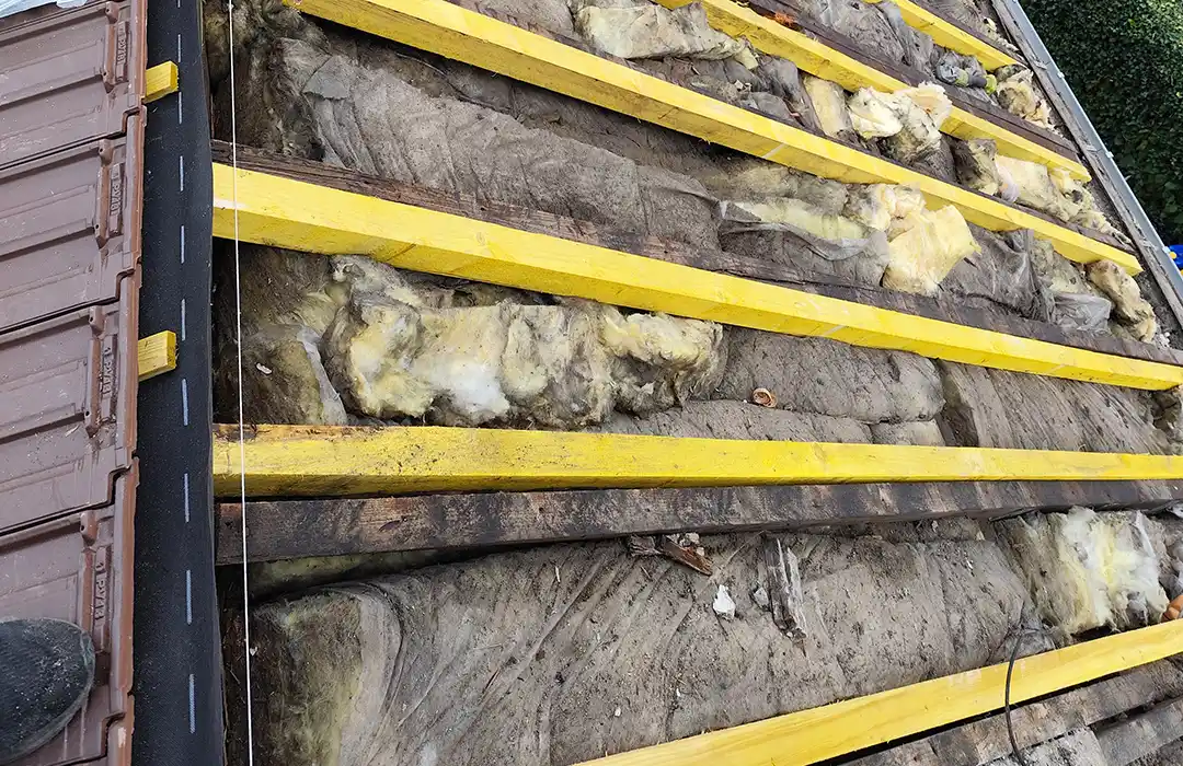 Vue rapprochée liteaux jaunes et isolation exposée - Teggy Couverture